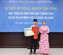 Phó Chủ tịch UBND thành phố Nguyễn Thị Anh Thi (bên phải) trao thưởng cho học sinh Cáp Kim Hoàng Bảo